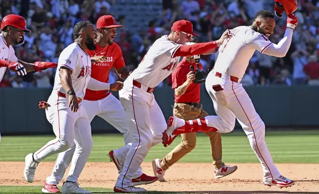 Los Angeles Angels outfielder Jo Adell, right, celebrates his three-run double to win the game against the San Francisco Giants with during the ninth inning of a baseball game Sunday, April 20, 2025, in Anaheim, Calif. (AP Photo/Wally Skalij)