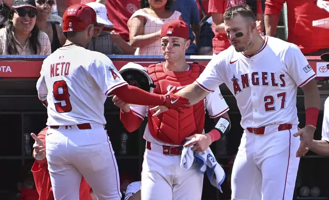 Los Angeles Angels shortstop Zach Neto (9) celebrates his solo home run against the San Francisco Giants with Los Angeles Angels outfielder Mike Trout (27) and Los Angeles Angels catcher Logan O'Hoppe during the fifth inning of a baseball game Sunday, April 20, 2025, in Anaheim, Calif. (AP Photo/Wally Skalij)
