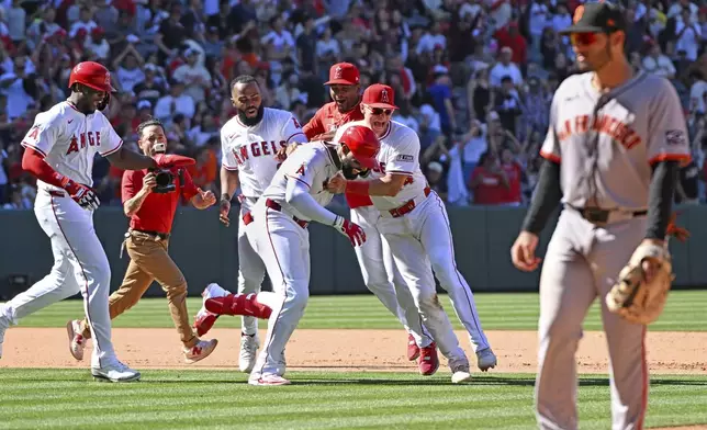 Los Angeles Angels outfielder Jo Adell, second from right, celebrates his three-run double to win the game against the San Francisco Giants with during the ninth inning of a baseball game Sunday, April 20, 2025, in Anaheim, Calif. (AP Photo/Wally Skalij)