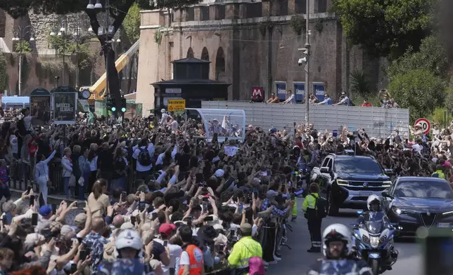 The coffin of Pope Francis, centre, is transported on its way to St. Mary Major where he will be buried, Rome, Saturday, April 26, 2025. (AP Photo/Antonio Calanni)