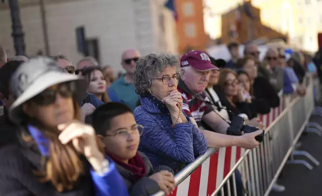 People watch the funeral of Pope Francis on a monitor outside St. Mary Major Basilica in Rome Saturday, April 26, 2025. (AP Photo/Francisco Seco)