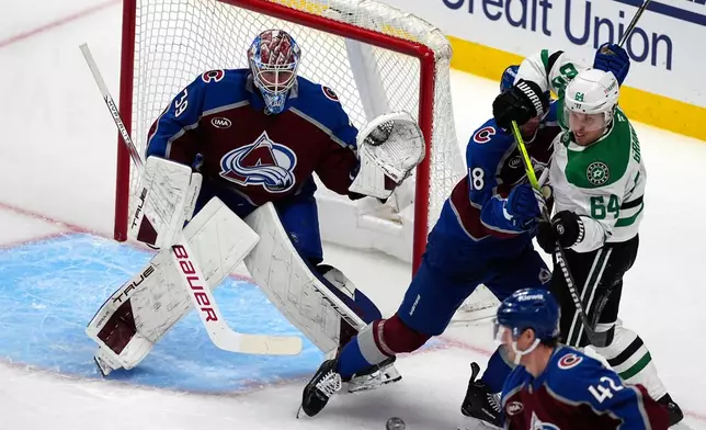 Dallas Stars center Mikael Granlund, right, struggles to redirect the puck as Colorado Avalanche defenseman Samuel Girard, center, protects goaltender Mackenzie Blackwood in the first period of Game 3 of an NHL hockey first-round playoff series Wednesday, April 23, 2025, in Denver. (AP Photo/David Zalubowski)