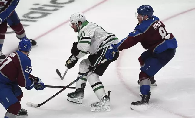 Dallas Stars center Tyler Seguin, center, drives past Colorado Avalanche defenseman Cale Makar, right, to shoot the puck past Colorado Avalanche left wing Jonathan Drouin for the winning score in overtime of Game 3 of an NHL hockey first-round playoff series Wednesday, April 23, 2025, in Denver. (AP Photo/David Zalubowski)