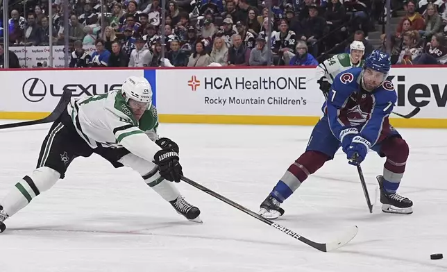 Dallas Stars center Roope Hintz, left, misses a pass as Colorado Avalanche defenseman Devon Toews covers in the second period of Game 3 of an NHL hockey first-round playoff series Wednesday, April 23, 2025, in Denver. (AP Photo/David Zalubowski)