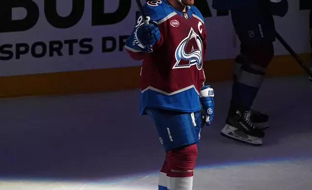 Colorado Avalanche left wing Gabriel Landeskog acknowledges fans as they applaud after a video tribute for the player during a time out in the first period of Game 3 of an NHL hockey first-round playoff series against the Dallas Stars Wednesday, April 23, 2025, in Denver. (AP Photo/David Zalubowski)