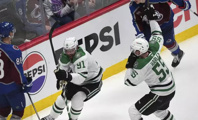 Dallas Stars center Tyler Seguin, front center, celebrates after scoring the winning goal with defenseman Thomas Harley, front right, as Colorado Avalanche center Martin Necas, front left, and defenseman Cale Makar look on in overtime of Game 3 of an NHL hockey first-round playoff series Wednesday, April 23, 2025, in Denver. (AP Photo/David Zalubowski)
