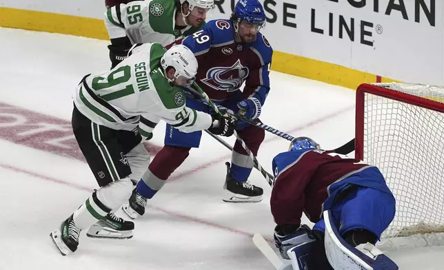 Dallas Stars center Tyler Seguin, front left, puts a shot on Colorado Avalanche goaltender Mackenzie Blackwood, front right, as defenseman Samuel Girard, back right, blocks Dallas center Matt Duchene in the first period of Game 3 of an NHL hockey first-round playoff series Wednesday, April 23, 2025, in Denver. (AP Photo/David Zalubowski)