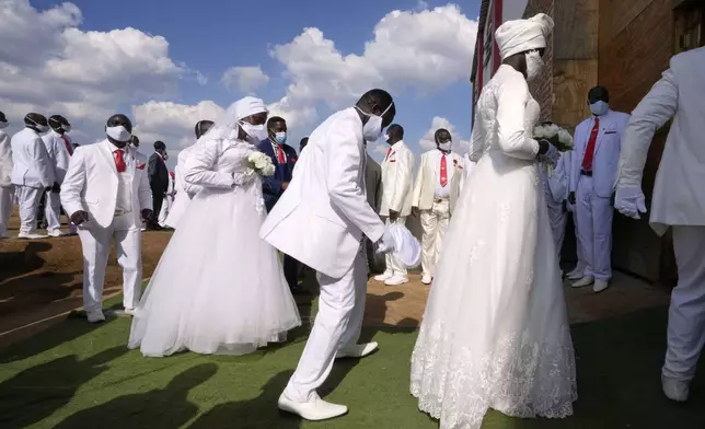 Couples dance as they enter the church building during mass Easter weddings for 3,000 people, some polygamous, at the International Pentecost Holiness Church, in Heidelberg, east of Johannesburg, South Africa, Sunday, April 20, 2025. (AP Photo/Themba Hadebe)