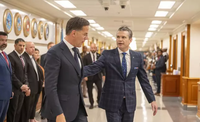 Defense Secretary Pete Hegseth, right, walks to a meeting with NATO Secretary General Mark Rutte, left, following an Honor Cordon at the Pentagon, Thursday, April 24, 2025 in Washington. (AP Photo/Kevin Wolf)