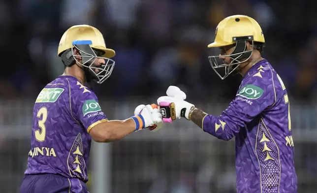 Kolkata Knight Riders' captain Ajinkya Rahane, left, and Sunil Narine greets each other during the Indian Premier League cricket match between Kolkata Knight Riders and Lucknow Super Giants at Eden Gardens in Kolkata, India, Tuesday, April 8, 2025. (AP Photo/Bikas Das)