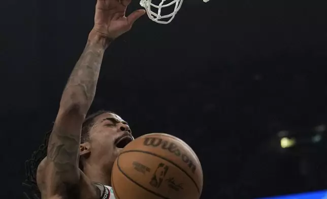 Memphis Grizzlies guard Ja Morant (12) dunks the ball during the first half of an NBA play-in tournament basketball game against the Dallas Mavericks, Friday, April 18, 2025, in Memphis, Tenn. (AP Photo/George Walker IV)
