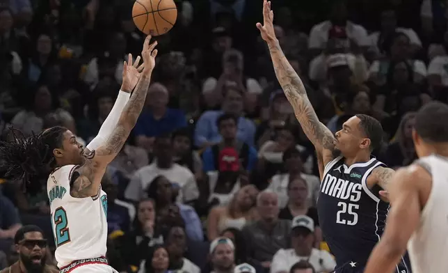 Memphis Grizzlies guard Ja Morant, left, shoots the ball over Dallas Mavericks forward P.J. Washington (25) during the second half of an NBA play-in tournament basketball game Friday, April 18, 2025, in Memphis, Tenn. (AP Photo/George Walker IV)