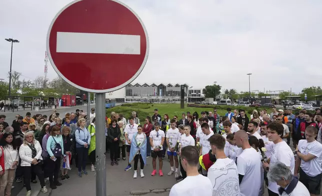 People stand in silence to commemorate the 16 victims killed after a railway concrete canopy fell in November, during a farewell ceremony for Serbia's protesting students embarking on 2,000-kilometer (1,200-mile) run to Brussels aimed to draw European Union attention to their months-long struggle against corruption and for the rule of law in Novi Sad, Serbia, Friday, April 25, 2025. (AP Photo/Darko Vojinovic)