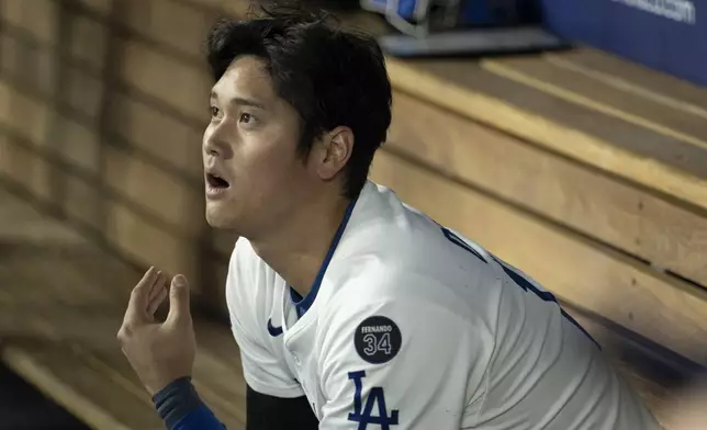 Los Angeles Dodgers' Shohei Ohtani watches in the dugout during the second inning of a baseball game against the Miami Marlins in Los Angeles, Tuesday, April 29, 2025. (AP Photo/Kyusung Gong)
