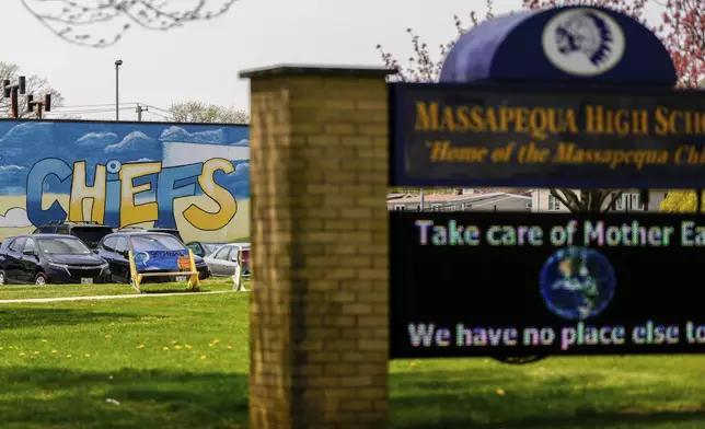 A marquee outside the Massapequa High School is backdropped by a "Chiefs" mascot mural, in Massapequa, N.Y., Friday, April 25, 2025. (AP Photo/Julia Demaree Nikhinson)