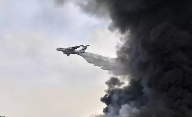 A revolutionary Guard firefighting airtanker drops water on the fire, Sunday, April 27, 2025, after a massive explosion and fire rocked a port near the southern port city of Bandar Abbas, Iran, on Saturday. (AP Photo/Mahdi Nori/Fars News agency)