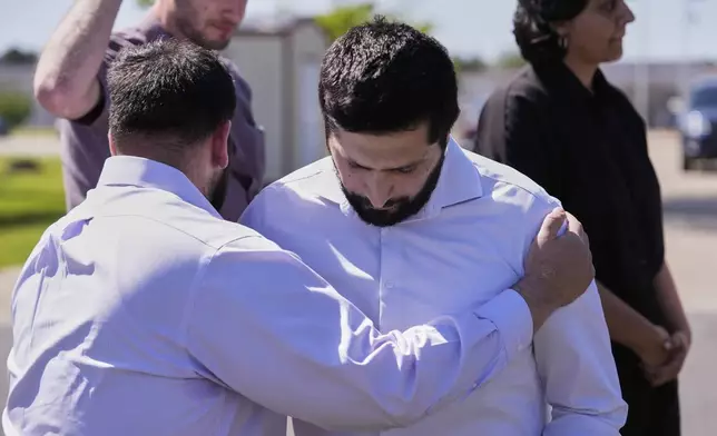 A supporter who identified himself as Palestinian is hugged by a fellow supporter after speaking at a news conference outside the Central Louisiana ICE Processing Center in Jena, La., after an immigration hearing for Mahmoud Khalil, the Columbia University activist facing deportation for his role in pro-Palestinian campus protests, Friday, April 11, 2025. (AP Photo/Gerald Herbert)