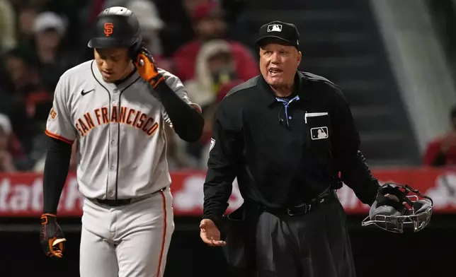 San Francisco Giants' Wilmer Flores, left, walks away after having words with home plate umpire Brian O'Nora following a strikeout during the sixth inning of a baseball game against the Los Angeles Angels, Friday, April 18, 2025, in Anaheim, Calif. (AP Photo/Mark J. Terrill)