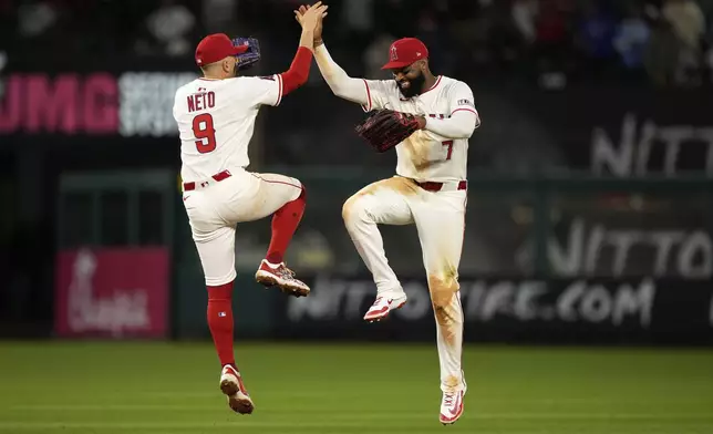 Los Angeles Angels' Zach Neto, left, and Jo Adell congratulate each other after the Angels defeated the San Francisco Giants 2-0 in a baseball game Friday, April 18, 2025, in Anaheim, Calif. (AP Photo/Mark J. Terrill)
