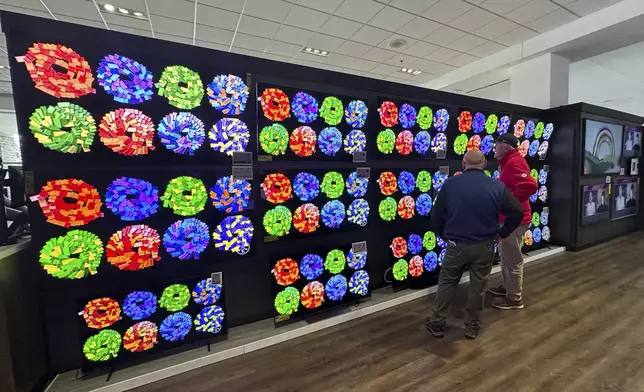 Customers shop televisions at a retail store in Glenview, Ill., Thursday, April 3, 2025. (AP Photo/Nam Y. Huh)
