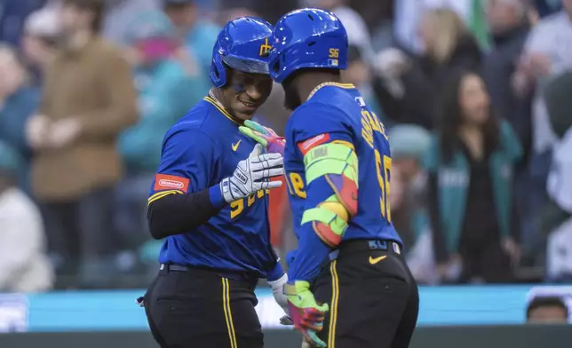 Seattle Mariners' Jorge Polanco, left, celebrates with Randy Arozarena after hitting a solo home run during the first inning of a baseball game against the Texas Rangers, Friday, April 11, 2025, in Seattle. (AP Photo/Stephen Brashear)