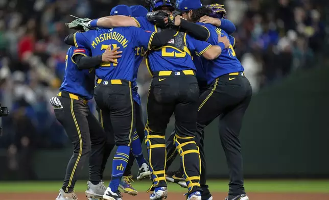 From left, Seattle Mariners second baseman Leo Rivas, third baseman Miles Mastrobuoni, catcher Cal Raleigh and relief pitcher Andres Munoz celebrate after a baseball game against the Texas Rangers, Friday, April 11, 2025, in Seattle. (AP Photo/Stephen Brashear)