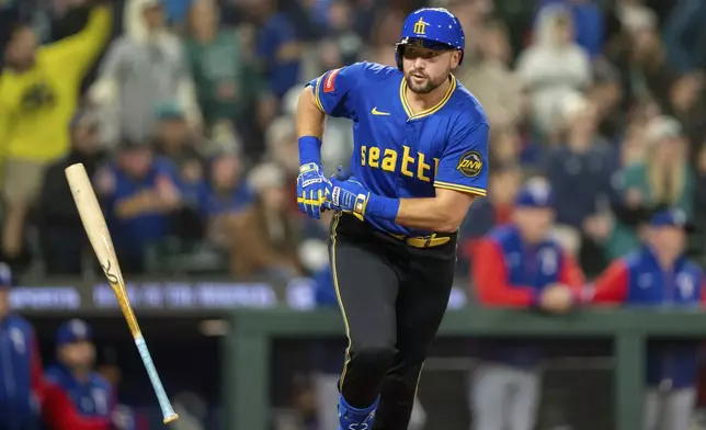 Seattle Mariners' Cal Raleigh tosses his bat after hitting a two-run home run during the eighth inning of a baseball game against the Texas Rangers, Friday, April 11, 2025, in Seattle. (AP Photo/Stephen Brashear)