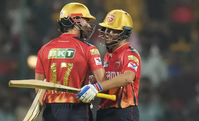 Punjab Kings' Nehal Wadhera celebrates with batting partner Marcus Stoinis after their win against Royal Challengers Bengaluru during the Indian Premier League cricket match at Chinnaswamy Stadium in Bengaluru, India, Friday, April 18, 2025. (AP Photo/Aijaz Rahi)
