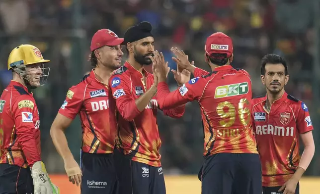 Punjab Kings' Harpreet Brar, center, celebrates with teammates the dismissal of Royal Challengers Bengaluru's Yash Dayal during the Indian Premier League cricket match between Royal Challengers Bengaluru and Punjab Kings at Chinnaswamy Stadium in Bengaluru, India, Friday, April 18, 2025. (AP Photo/Aijaz Rahi)