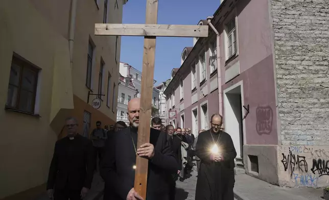 People attend the Way of Cross ceremony to mark Good Friday in the Old City of Tallinn, Estonia, during Holy Week, Friday, April 18, 2025. (AP Photo/Sergei Grits)
