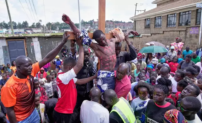 Christians reenact the crucifixion of Jesus Christ in a Way of the Cross procession on Good Friday during Holy Week in the informal settlement of Kibera in Nairobi, Kenya, Friday, April 18, 2025. (AP Photo/Brian Inganga)