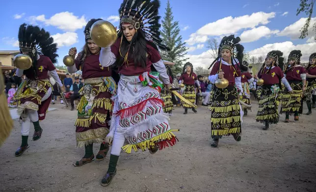 Members of the Danza Señor San Jose dance group perform behind El Santuario De Chimayo in Northern New Mexico during Holy Week on Good Friday, April 18, 2025. Chimayo, N.M. (AP Photo/Roberto E. Rosales)