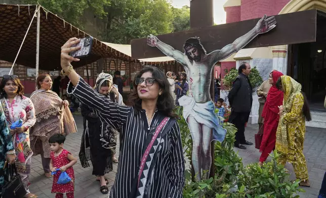 A Christian woman takes a selfie as she attends a prayer services at St. Anthony Church, marking Good Friday, in Lahore, Pakistan, Friday, April 18, 2025. (AP Photo/K.M. Chaudary)