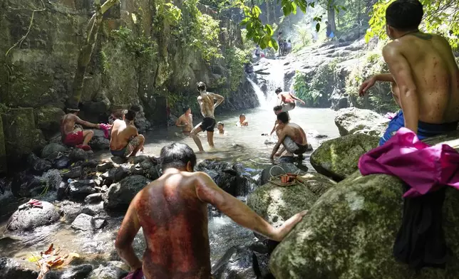 Penitents wash their bloodied backs after flagellating themselves on Good Friday in Kalayaan town, Laguna province, Philippines, April 18, 2025. (AP Photo/Aaron Favila)