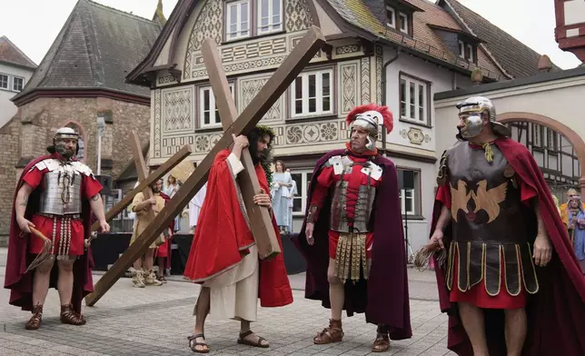 Members of the Italian community take part in a re-enactment of the crucifixion of Jesus Christ on Good Friday, in Bensheim, Germany, Friday, April 18, 2025. (AP Photo/Matthias Schrader)