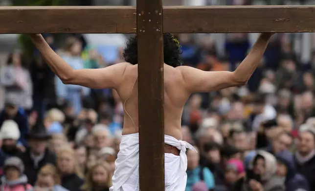a member of the Italian community takes part in a re-enactment of the crucifixion of Jesus Christ on Good Friday, in Bensheim, Germany, Friday, April 18, 2025. (AP Photo/Matthias Schrader)