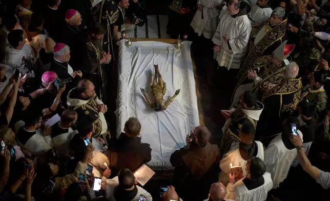 Catholic clergymen take part in a Good Friday ceremony reenacting the funeral of Jesus Christ at the Church of the Holy Sepulcher, the site where according to tradition Jesus was crucified and buried, in the Old City of Jerusalem on Friday, April 18, 2025. (AP Photo/Leo Correa)