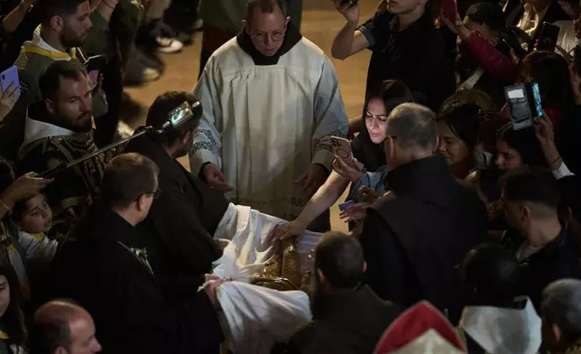 Catholic clergymen take part in a Good Friday ceremony reenacting the funeral of Jesus Christ at the Church of the Holy Sepulcher, the site where according to tradition Jesus was crucified and buried, in the Old City of Jerusalem on Friday, April 18, 2025. (AP Photo/Leo Correa)