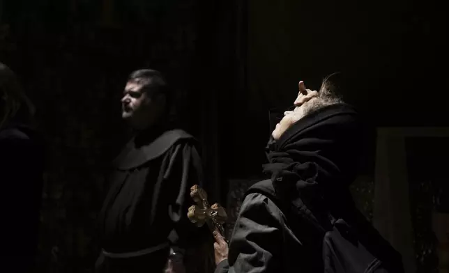 Christian pilgrims hold crosses during Good Friday procession at the Church of the Holy Sepulchre, where many Christians believe Jesus was crucified, buried and rose from the dead, in the Old City of Jerusalem on Friday, April 18, 2025. (AP Photo/Maya Alleruzzo)