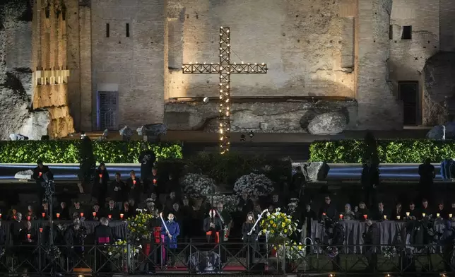 Cardinal Baldassare Reina, Vicar General of Pope Francis for the Diocese of Rome, leads the procession in front of the Colosseum during the Via Crucis (Latin for 'way of the cross') in Rome, Friday, April 18, 2025. (AP Photo/Andrew Medichini)