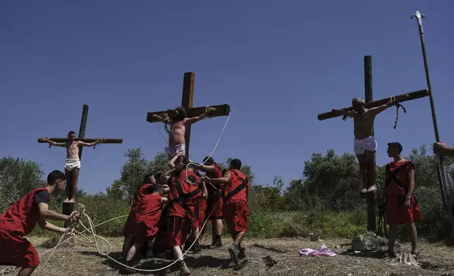 Lebanese men are raised from the cross during a reenactment of Jesus Christ's sufferings as part of Good Friday rituals, in Quraye near the southern port city of Sidon, Lebanon, Friday, April 18, 2025. (AP Photo/Hassan Ammar)