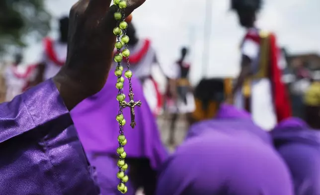 A member of the St Francis Catholic Church holds a rosary as they take part in a Way of the Cross re-enactment of the crucifixion of Jesus Christ on Good Friday during Holy Week in Lagos, Nigeria, Friday, April 18, 2025. (AP Photo/Sunday Alamba)