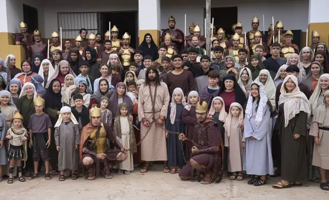 Actors pose for a picture before reenacting the crucifixion of Jesus in a Way of The Cross procession during Holy Week in Atyra, Paraguay, Friday, April 18, 2025. David Rodi, a grade school physical health teacher, center, plays the role of Jesus. (AP Photo/Jorge Saenz)