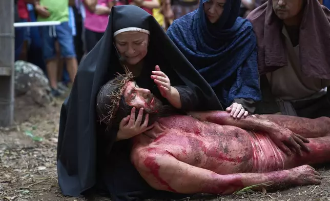 Actors reenact the crucifixion of Jesus with a Way of The Cross procession on Good Friday during Holy Week in Atyra, Paraguay, Friday, April 18, 2025. (AP Photo/Jorge Saenz)
