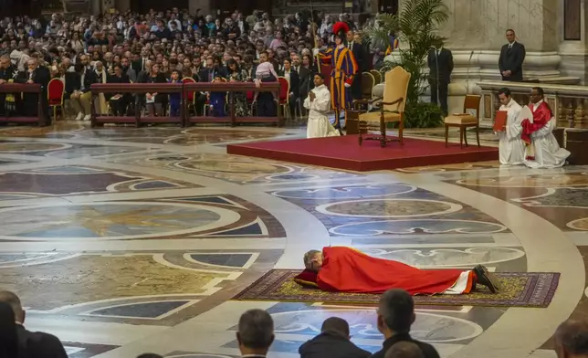 Delegate of the Holy Father, Cardinal Claudio Gugerotti, Prefect of the Dicastery for the Oriental Churches, prostrates himself during the Good Friday service he led inside St. Peter's Basilica at the Vatican, Friday, April 18, 2025. (AP Photo/Alessandra Tarantino)