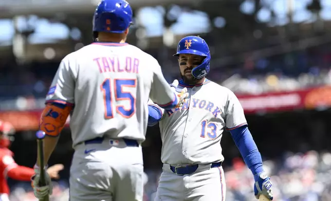 New York Mets' Luis Torrens (13) is greeted by Tyrone Taylor (15) after scoring on a single by Luisangel Acuna during the first inning of a baseball game against the Washington Nationals, Sunday, April 27, 2025, in Washington. (AP Photo/Nick Wass)