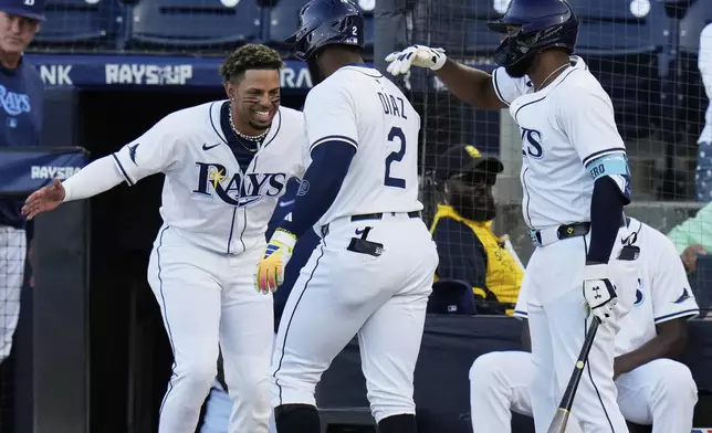 Tampa Bay Rays' Yandy Díaz (2) celebrates with Christopher Morel and Junior Caminero after hitting a home run off Boston Red Sox pitcher Tanner Houck during the first inning of a baseball game Monday, April 14, 2025, in Tampa, Fla. (AP Photo/Chris O'Meara)