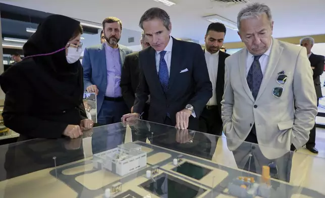 In this photo released by the Atomic Energy Organization of Iran, International Atomic Energy Agency (IAEA) Director General, Rafael Mariano Grossi, center, visits an exhibition of Iran's nuclear achievements, in Tehran, Iran, Thursday, April 17, 2025. (Atomic Energy Organization of Iran via AP)