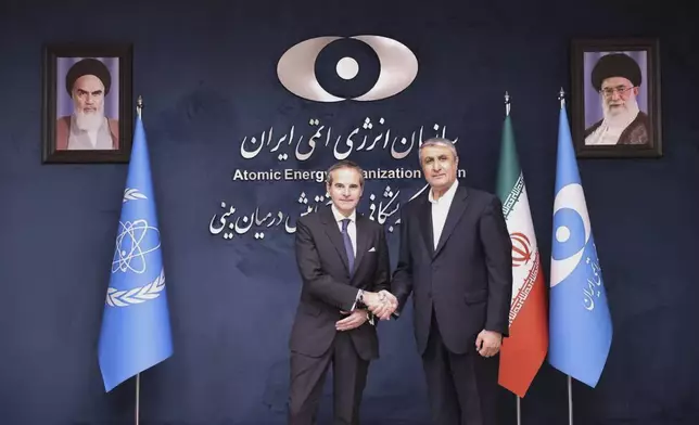 In this photo released by the Atomic Energy Organisation of Iran, International Atomic Energy Agency (IAEA) Director General, Rafael Mariano Grossi, left, shakes hands with head of the Atomic Energy Organization of Iran Mohammad Eslami, at the Atomic Energy Organisation of Iran, in Tehran, Iran, Thursday, April 17, 2025. (Atomic Energy Organisation of Iran via AP)