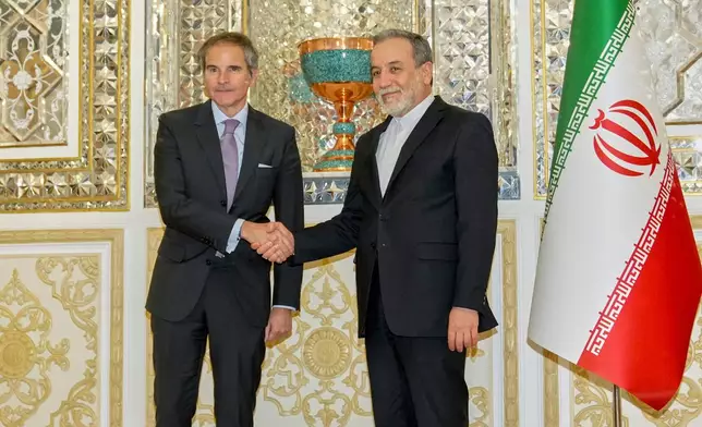 In this photo released by the Iranian Foreign Ministry, Foreign Minister Abbas Araghchi, right, shakes hands with the International Atomic Energy Agency (IAEA) Director General Rafael Mariano Grossi prior to their meeting in Tehran, Iran, Wednesday, April 16, 2025. (Iranian Foreign Ministry via AP)